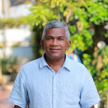 Mr Nawarathna standing in front of a tree